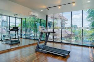um ginásio com duas bicicletas de exercício numa sala com janelas em De'Tonga Hotel em Medan