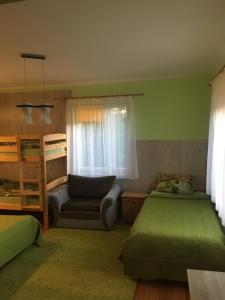 a bedroom with two beds and a chair and a bunk bed at Pie ābeles in Ventspils +37 photos