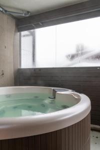 uma grande banheira na casa de banho com uma janela em Ski-Inn RukaValley em Ruka
