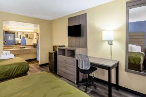 a hotel room with a desk and a bedroom at Quality Inn New Orleans I-10 East in New Orleans