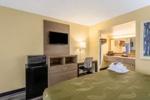 a hotel room with a bed and a desk with a television at Quality Inn New Orleans I-10 East in New Orleans