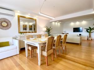 uma sala de estar com uma mesa e cadeiras e um sofá em Home Out Luxury Marina Apartment - 2 Bedrooms Sea View em Vilamoura