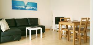 ein Wohnzimmer mit einem grünen Sofa und einem Tisch in der Unterkunft Easy-Living Apartments Lindenstrasse 48 in Luzern