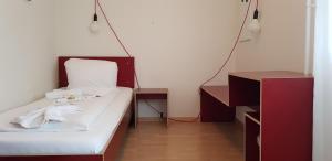 ルツェルンにあるEasy-Living Apartments Lindenstrasse 48のベッドとデスクが備わる小さな客室です。
