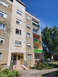 duży ceglany budynek z klatką schodową przed nim w obiekcie Mátrix apartman w mieście Békéscsaba