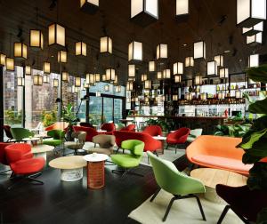 ein Restaurant mit bunten Stühlen, Tischen und Fenstern in der Unterkunft citizenM New York Times Square in New York