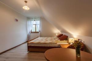a small bedroom with a bed and a table at Dom Gościnny na Górce in Leszczewek