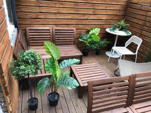a patio with two benches and a table and plants at Kamilla's Rooms London Zone-1 in London