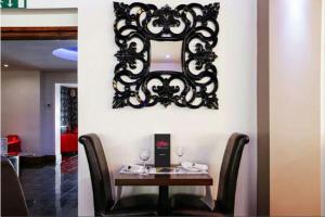 a table with two chairs and a mirror on a wall at Ashiana in Newark-on-Trent