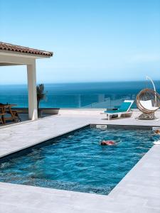 a person swimming in a swimming pool in a villa at Villa Mare d'argentu La solenzara in Sari Solenzara
