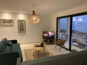 a living room with a couch and a tv at Villa Mare d'argentu La solenzara in Sari Solenzara