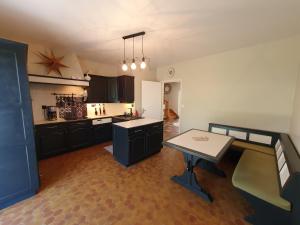 a kitchen with a table in the middle of it at LA MAISON DU MUGUET - Accueil Chevaux - Horse Friendly in Liart