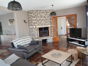 a living room with a couch and a fireplace at LA MAISON DU MUGUET - Accueil Chevaux - Horse Friendly in Liart