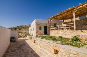 a stone house with a stone wall at Dimitrakis Guesthouse in Donoussa