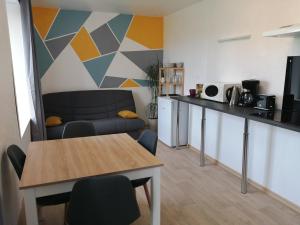 a living room with a table and a kitchen at Chambres " Orchidées " in Saint-Denis-de-Gastines