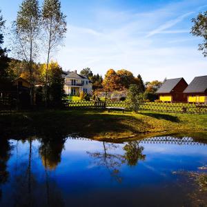 a view of a pond with houses in the background at Willa Kamieniec in Polańczyk