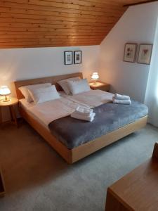 una camera da letto con un grande letto con due tavoli di SOBE U SIRRC a Bled