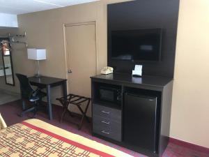 a hotel room with a television and a desk with a phone at Conner Hill Motor Lodge in Pigeon Forge