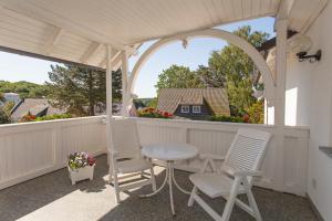 een patio met een tafel en stoelen en een prieel bij Ferienwohnungen Beyer in Binz
