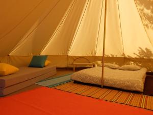a tent with a bed and a couch in a room at Uxa Paraiso in Penela