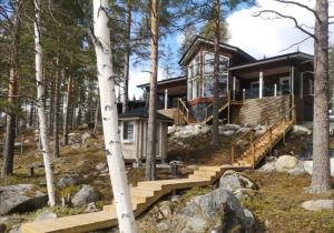 a house in the woods with wooden stairs at Ulpukkaranta in Ähtäri