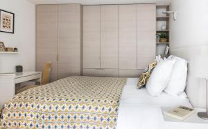 a small bedroom with a bed and a desk at Appartements - Le Logis Versaillais in Versailles