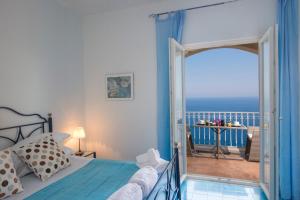 プライアーノにあるVilla San Giovanniのベッドルーム1室(ベッド1台付)、海を望むバルコニーが備わります。