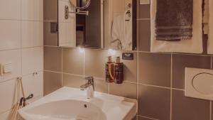 a bathroom with a sink and a mirror at Clarion Collection Hotel Odin in Gothenburg