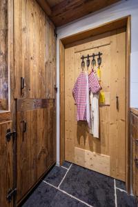 eine Scheunentür in einer Küche mit hängenden Kleidern in der Unterkunft Le Vatzerou in La Tzoumaz
