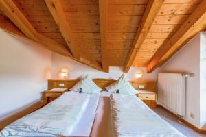 1 dormitorio con 2 camas y techos de madera en Petrushof Ferienwohnung Vogelspitz, en Oberwössen