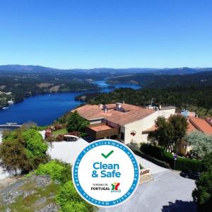 um sinal em frente a uma casa com um lago em Hotel Da Montanha em Pedrógão Pequeno