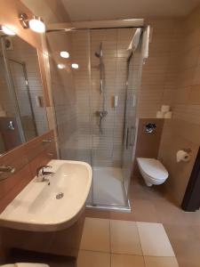 łazienka z prysznicem, umywalką i toaletą w obiekcie Apartamenty Aquarius z Aquacenter w Kołobrzegu