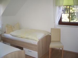 a small bedroom with a bed and a chair at Ferienwohnungen Schulze Oppach Oberlausitz - 5 Sterne in Oppach