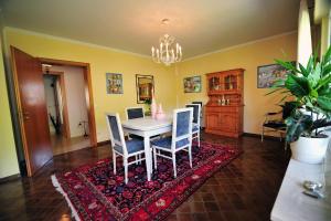 a dining room with a table and chairs on a rug at Gästehaus La Madonnina in Bad Breisig