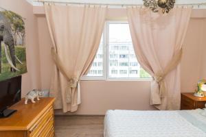 a bedroom with a bed and a window at ELEVATING MOMENTS in Burgas City
