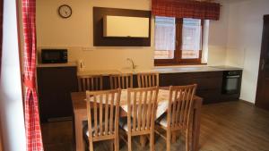 a kitchen with a table and chairs and a kitchen with a sink at Chatky pri penzióne Pribiskô in Zuberec