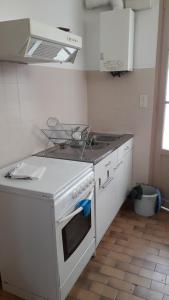 a kitchen with a white stove and a sink at Guéraçague Etcheverry Garaya in Saint-Jean-Pied-de-Port