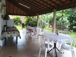 een patio met witte tafels en witte stoelen bij Ana Terra Barretos Casa de Campo in Barretos +14 foto's
