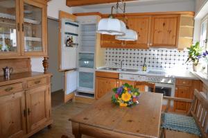 una cocina con armarios de madera y una mesa con flores. en Gästehaus La Madonnina, en Bad Breisig