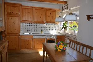 una cocina con armarios de madera y una mesa de madera con flores. en Gästehaus La Madonnina, en Bad Breisig