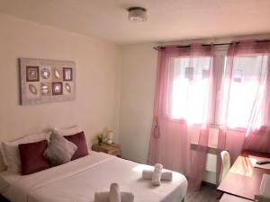 a bedroom with a bed and a window with pink curtains at Neoresid - Résidence Saint Marc in Rouen