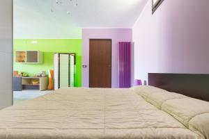 a large bed in a room with green and purple walls at The Loft Suite by BarbarHouse in Ostuni