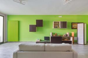 a living room with a couch and a green wall at The Loft Suite by BarbarHouse in Ostuni