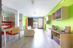 una cucina con pareti verdi e tavolo e sedie di The Loft Suite by BarbarHouse a Ostuni