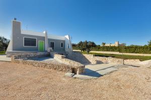 a house with a stone retaining wall in front of it at The Loft Suite by BarbarHouse in Ostuni