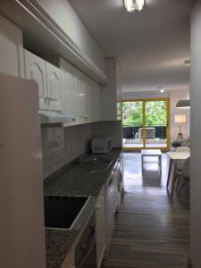 une cuisine avec des armoires blanches et un comptoir dans l'établissement Apartamento delante del puerto deportivo ., à Sant Carles de la Ràpita