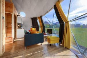 salon z dużymi oknami i niebieską kanapą w obiekcie Domki góralskie klapnioki w Leśnicy