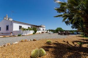 a house with a bench in the middle of a driveway at Monte da Lagoa in Altura