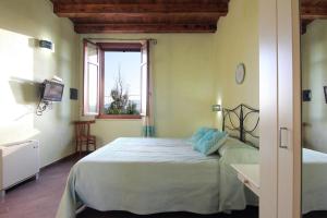 een slaapkamer met een bed in een kamer met een raam bij SU PASSU Country House in Fertilia
