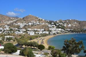 a view of a beach with white houses on a hill at Petra Holiday Village in Ios Chora